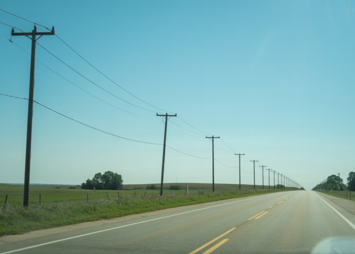 Rural highway with diminishing telephone poles illustrating perspective and depth.