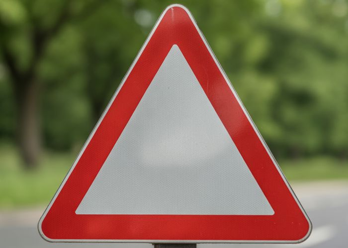 Red triangular traffic sign warning drivers of a potential hazard.