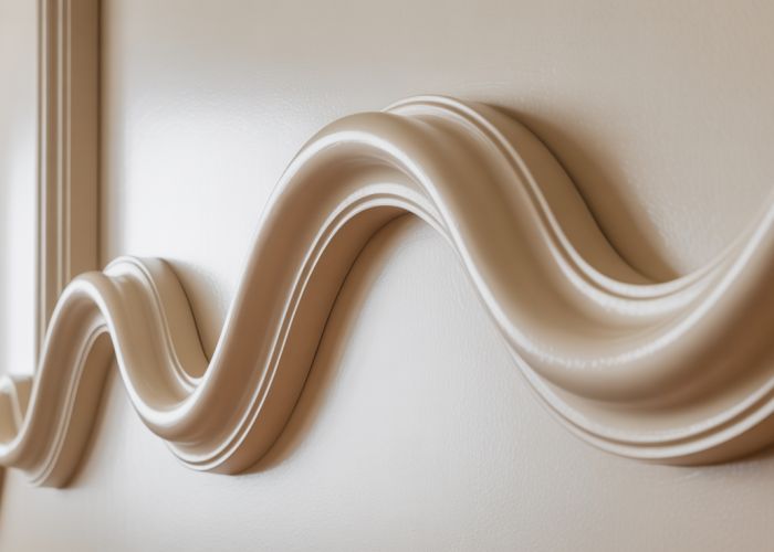 Close-up view of an S-shaped molding profile, highlighting its elegant curves and shadow detail.